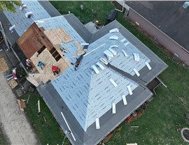 Action shot of roof replacement by Huskie Exteriors