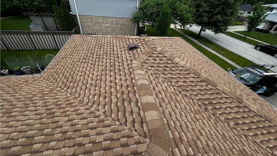 Wide view of a completed asphalt shingle roof with multiple hips and roof vents