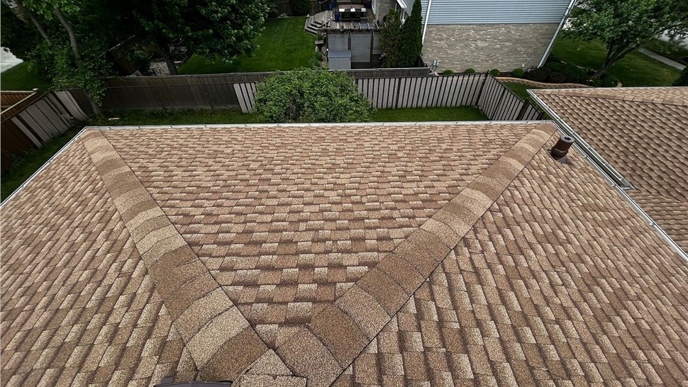 Architectural shingle roofing with finished ridge caps, roof vent, and pipe flashing