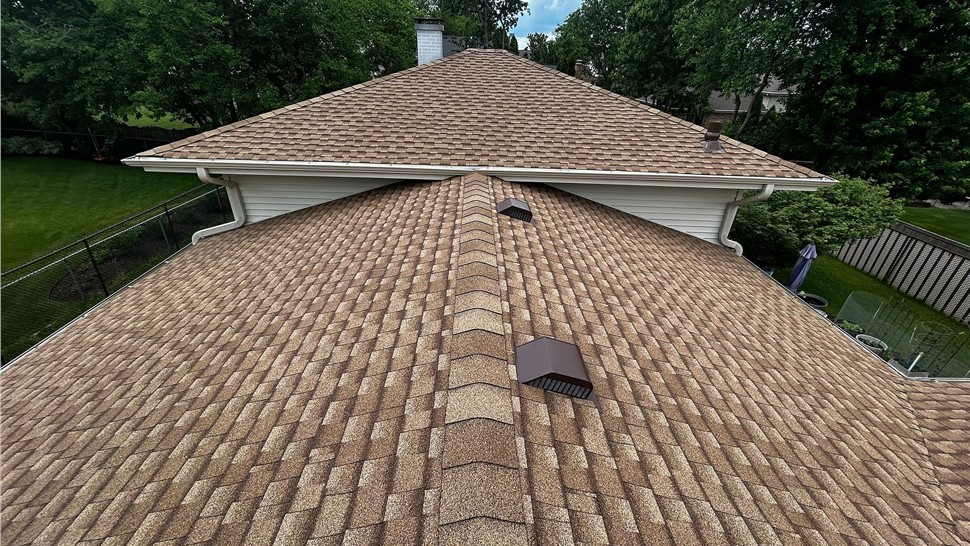 Completed residential roof replacement with architectural asphalt shingles and ridge caps