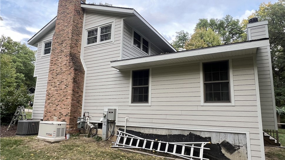 Old roof and worn siding on a Rockford, IL home before replacement by Huskie Exteriors.