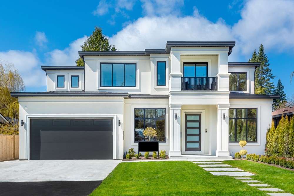 Beautiful contemporary white house with lush grass and blue sky twilight and daylight in Toledo Ohio