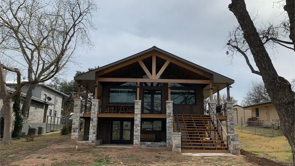 Elevated outdoor patio cover with timber framing and stone pillars built by JP Exteriors Outdoor Living.