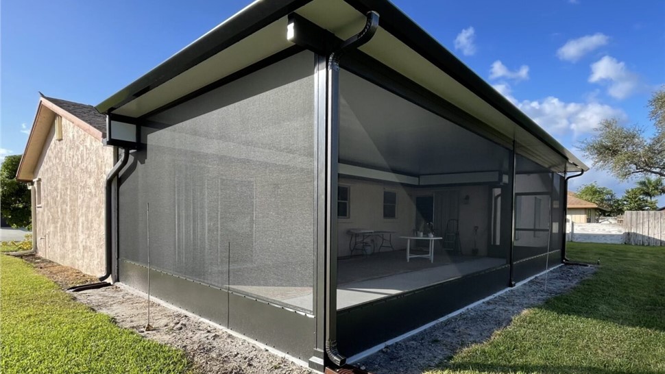 Modern Renaissance patio cover with screened enclosure installed by JP Exteriors Outdoor Living for a shaded backyard patio space.