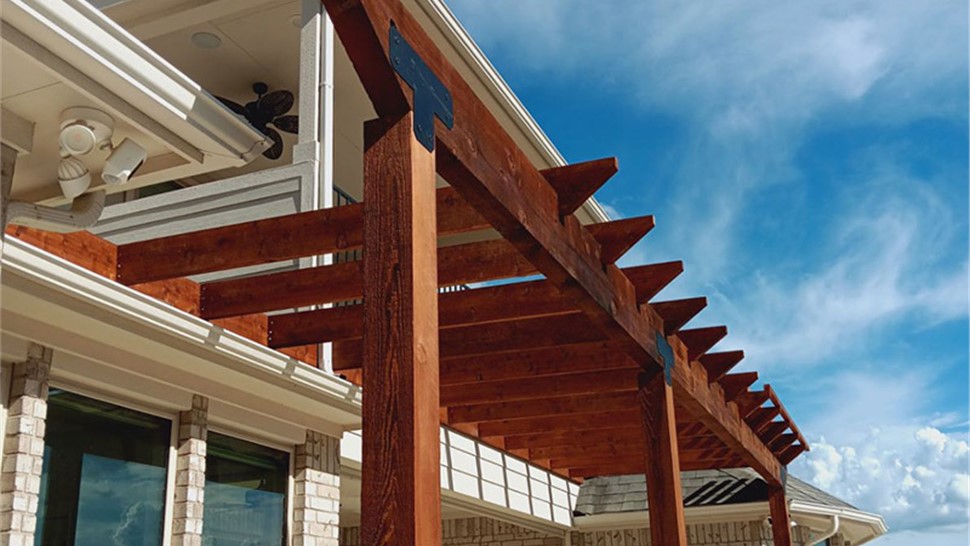Custom wood pergola installed by JP Exteriors Outdoor Living providing shade and style to a backyard patio.