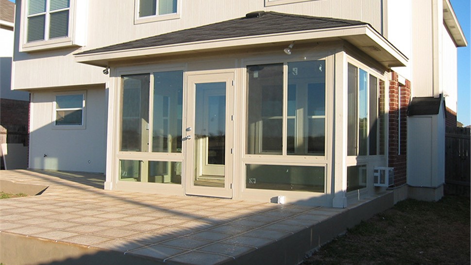 Custom sunroom addition with large windows built by JP Exteriors Outdoor Living extending backyard living space.