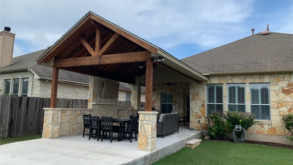Covered backyard cabana patio with wood beams and stone columns designed by JP Exteriors Outdoor Living.