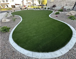 curved artificial turf lawn with concrete edging and rock landscaping