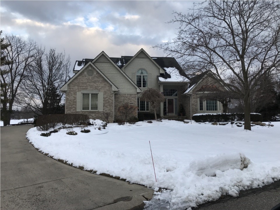 A beige suburban home in the snow.
