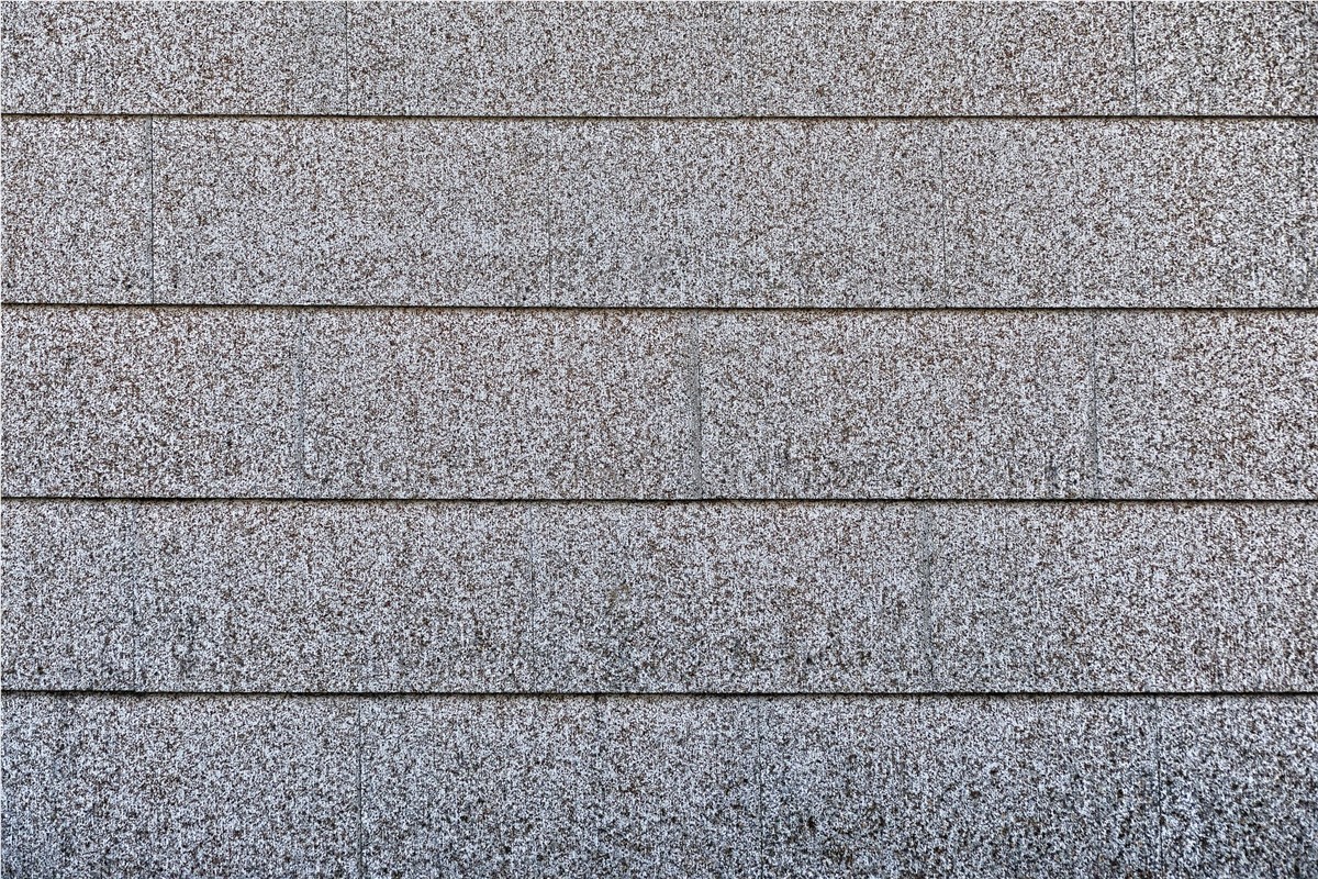 Up close view of a grey 3-tab shingled roof.