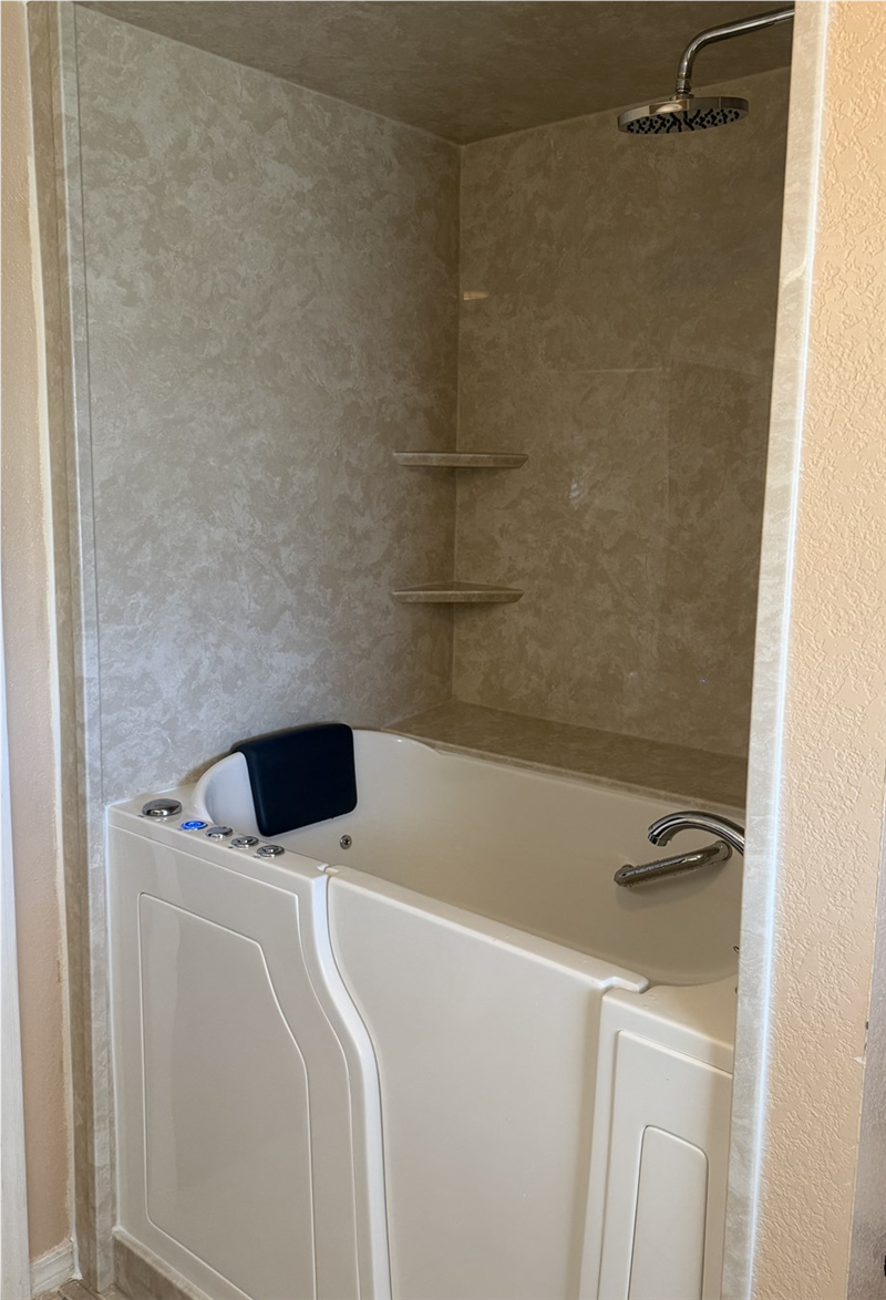 Completed walk-in tub installation in Iowa Park TX with acrylic surround, low-threshold entry, built-in seat, and grab handle for accessibility