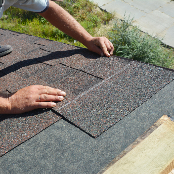 Roofer placing shingles on a roof