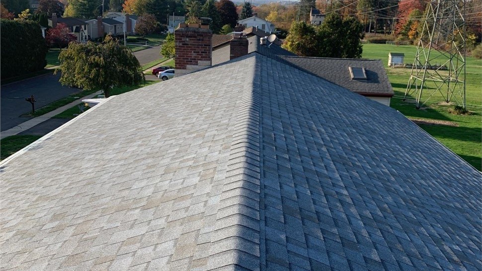 New architectural shingle roof installed on a home in Berlin, CT after removing old warped and moss-covered shingles.
