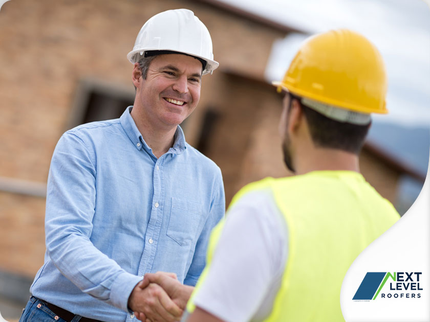 Two men wearing hard hats shaking hands