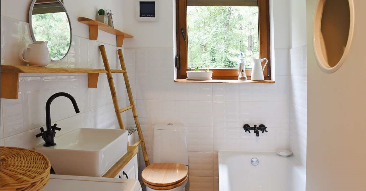 A modest and modern home bathroom with thoughtfully installed shelving that maximizes vertical storage space.