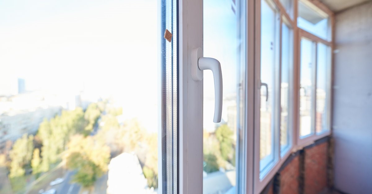 An interior view of casement windows on the second floor of a residential property. The windows overlook a busy street.