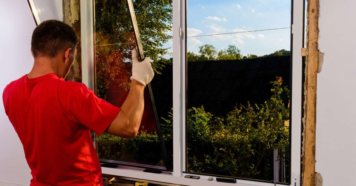 A professional contractor converting a wooden window frame into a vinyl window frame for his client.