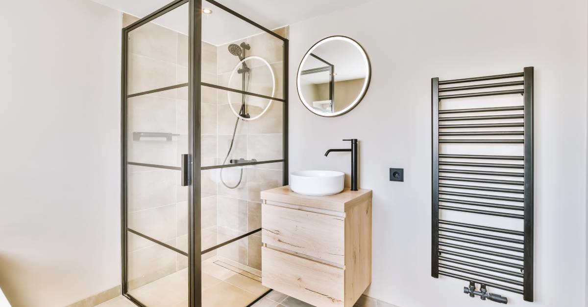 A modern, minimalist residential bathroom featuring smart gadgets and features, including an illuminated smart mirror.