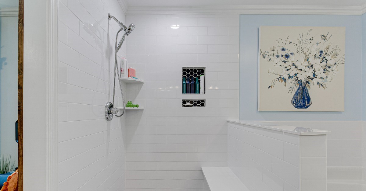  A modern open-concept shower that includes stylish and practical features, such as a built-in shelf and bench.