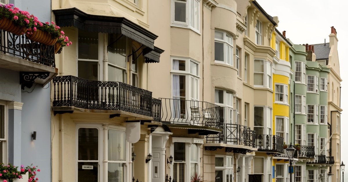 Old townhomes featuring classic exteriors with bay and bow windows, colorful exterior paint, and balcony gardens.