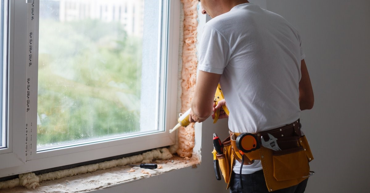 A professional contractor renovating his client’s window frames to increase insulation and overall energy efficiency.