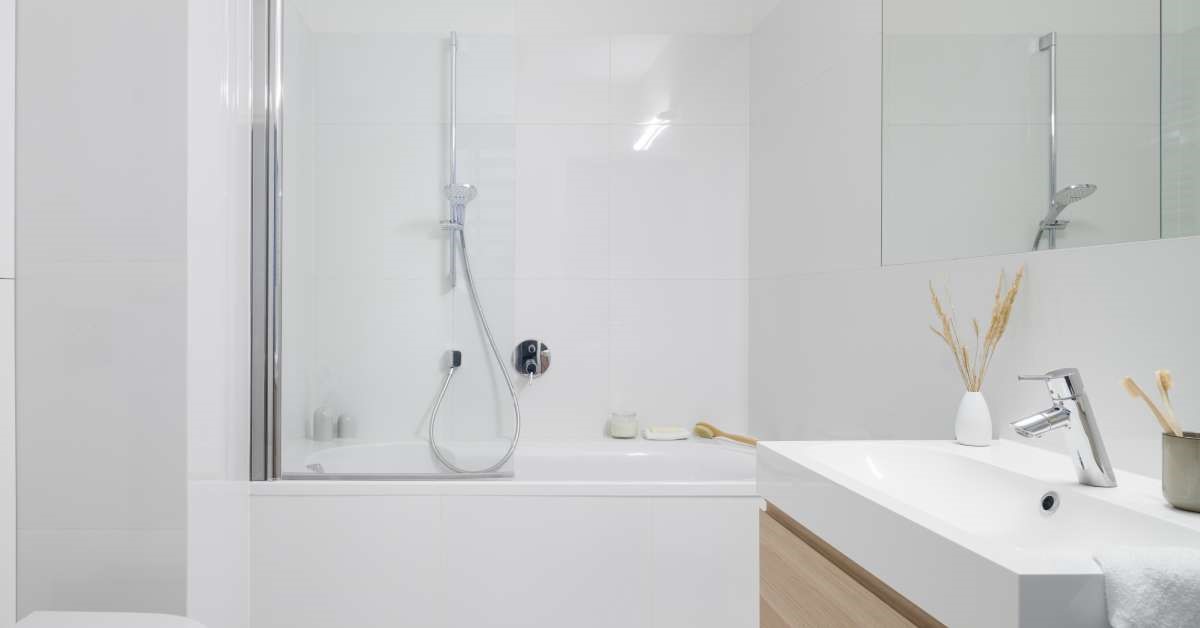 A modern, well-lit residential home bathroom. The bathtub is dual-purpose, featuring an adjustable showerhead.