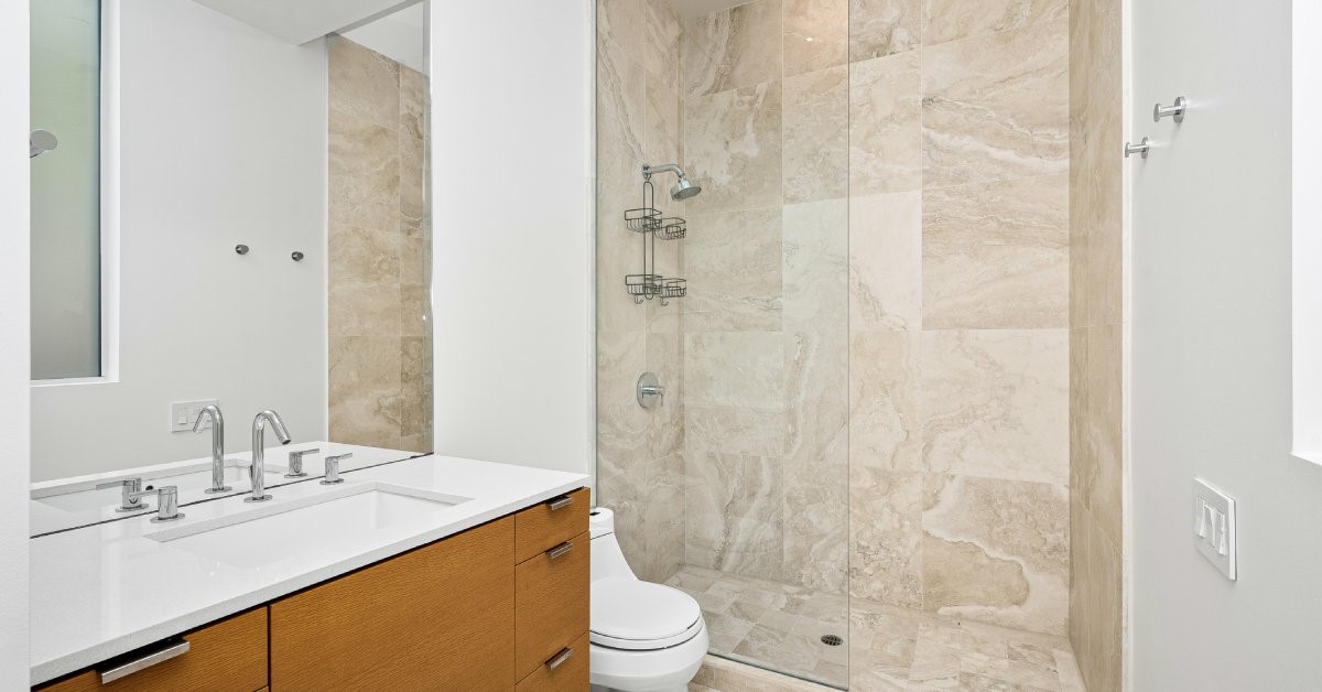 A newly renovated home restroom that includes a zero-threshold, accessible shower stall.