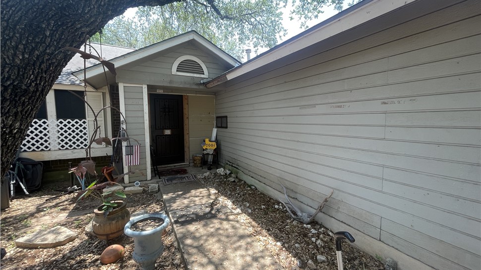 Before exterior remodel in Austin TX with original siding and windows