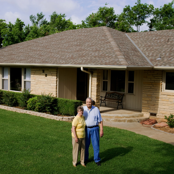 San Antonio homeowner enjoying a well-maintained landscape protected by proper gutters.