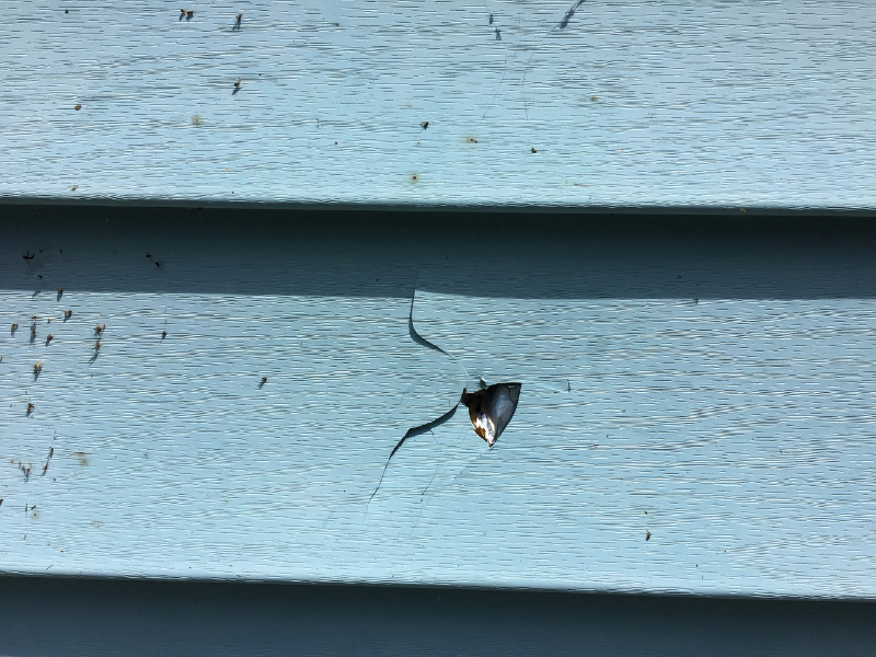 An image showing a home with damaged siding, in need of new repair. 