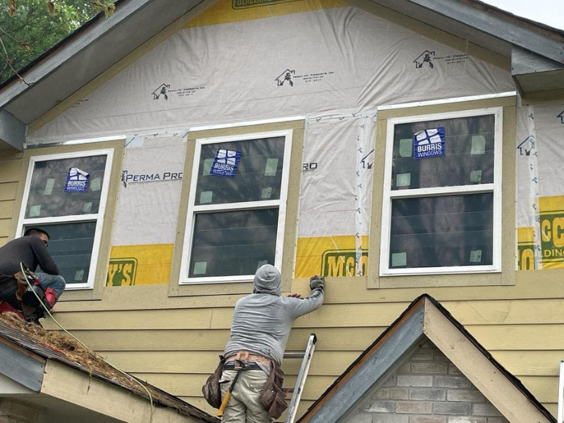 An image showing Spartan Roofing &amp; Siding technicians installing high-quality siding on a San Antonio home.