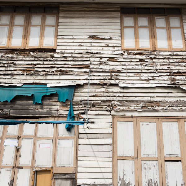 An image showing a house with peeling and faded paint.