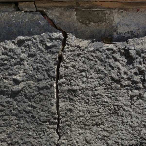 A photograph showing soil movement affecting an Austin home's foundation from heavy rains or flooding.