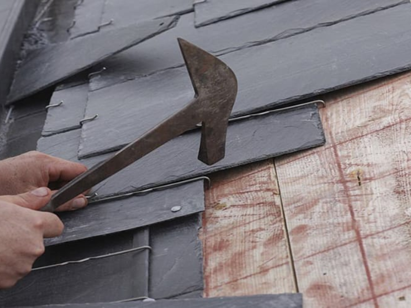 An image showing a roofing contractor installing a slate roof in San Antonio, TX.