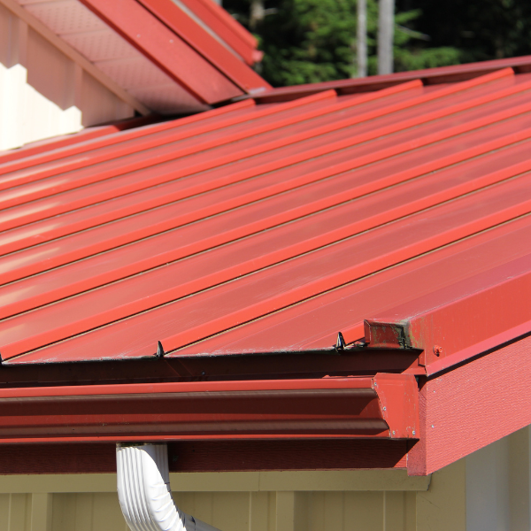 An image showing a brick house with a standing seam metal roof. 