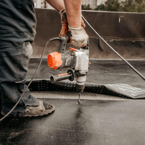 An image showing a contractor engaging in commercial roof repair. 