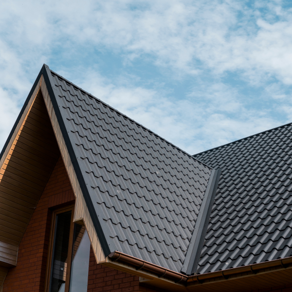 An image showing a brick house with a new metal roof in San Antonio. 
