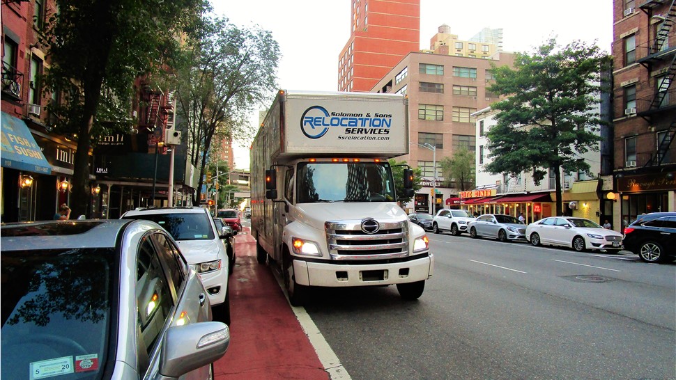 Solomon & Sons employee relocation moving truck parked on city street.