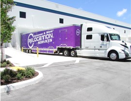 Purple Fort Lauderdale moving truck at warehouse.