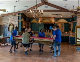 Florida movers placing a billards table.