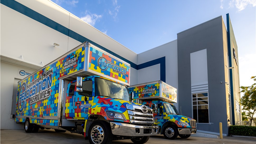 Colorful Solomon & Sons moving truck parked outside a modern relocation facility on a sunny day.