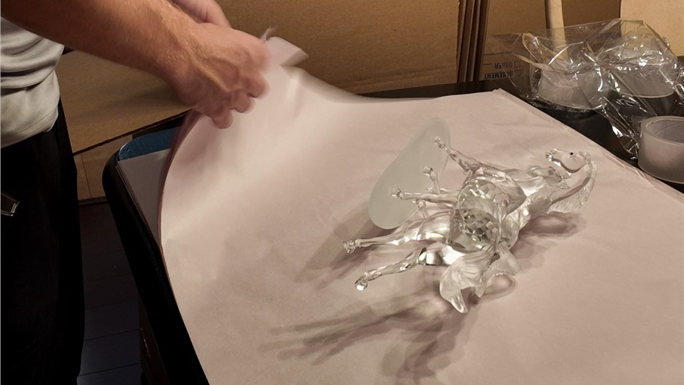 Mover wrapping fragile glass decor with protective packing paper