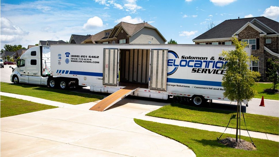 Solomon & Sons trailer with ramp down and doors open during a suburban long-distance move.