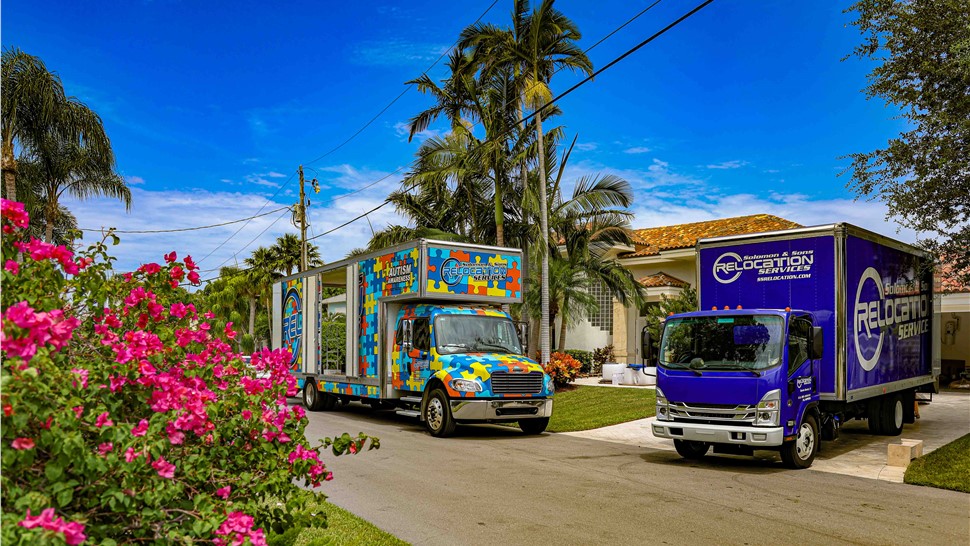 Movers loading a wardrobe box up a ramp into a Solomon & Sons moving truck