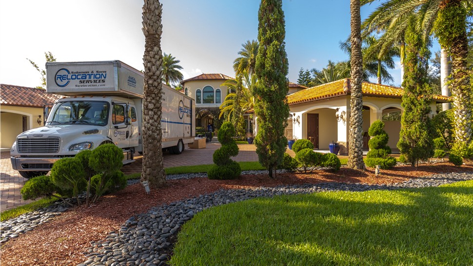Solomon & Sons moving truck parked near the front yard of a Florida home during a residential move.