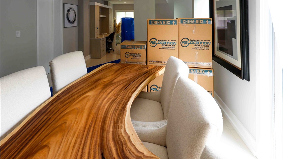 Stacked Solomon & Sons moving boxes in a dining room during a professionally organized home move