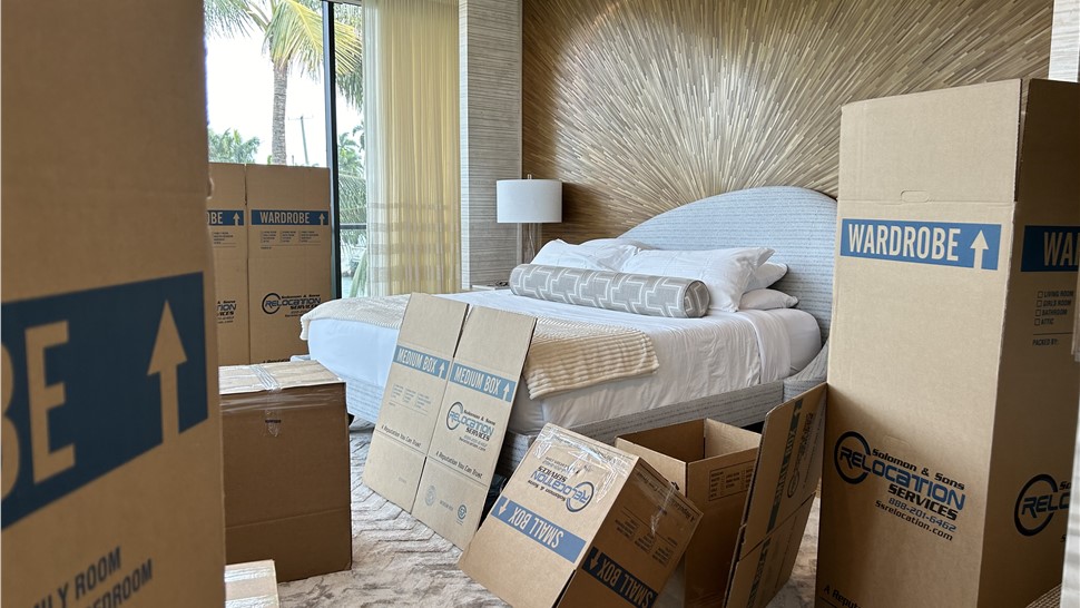 Packed bedroom with moving boxes prepared for a residential relocation by professional movers.