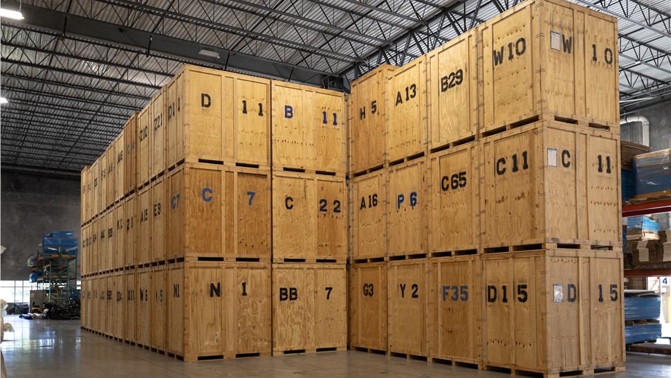 Wooden storage vaults stacked in a secure warehouse for moving, storage, and relocation services.