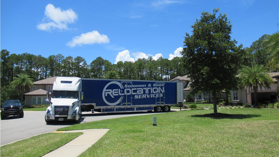 Solomon & Sons Relocation Services long-distance moving truck parked in a residential neighborhood preparing for a move.