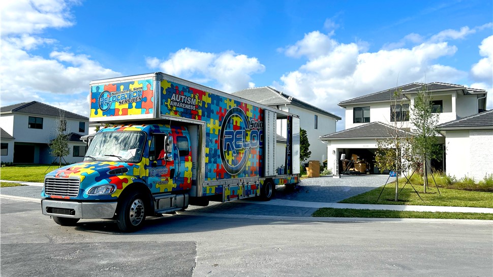 Colorful Solomon & Sons moving truck parked outside a home in a residential neighborhood.